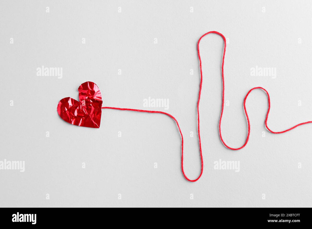 Red crumpled paper heart and thread on gray background, top view Stock ...
