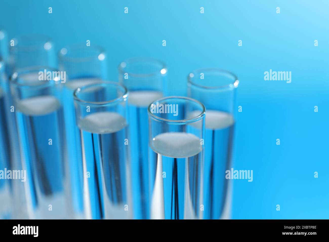 Many glass test tubes on light blue background, closeup Stock Photo - Alamy