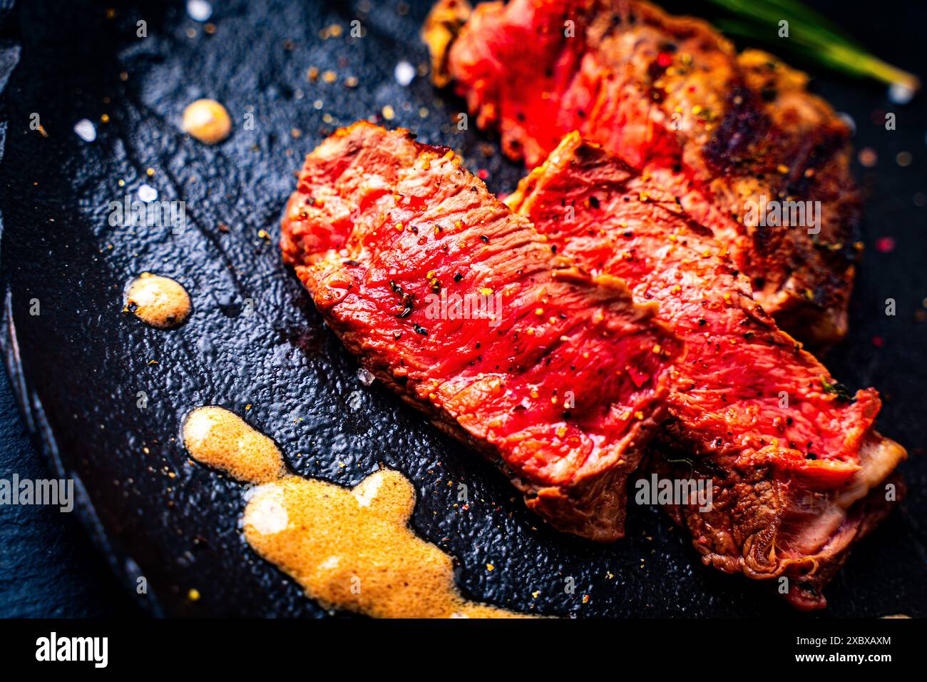 Rar marbled beef steak with sauce on a black mica plate. High quality photo Stock Photo