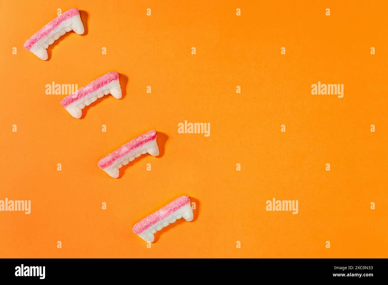 Gummy vampire teeth candies isolated on orange background, Halloween