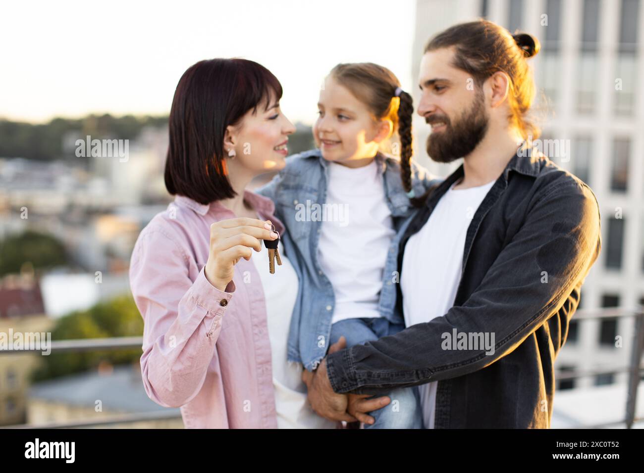 Happy family with new house keys on rooftop Stock Photo - Alamy
