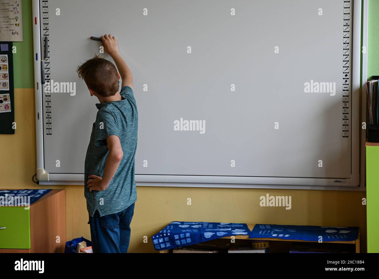 Schoolboy is writing on an empty whiteboard in a classroom Stock Photo ...