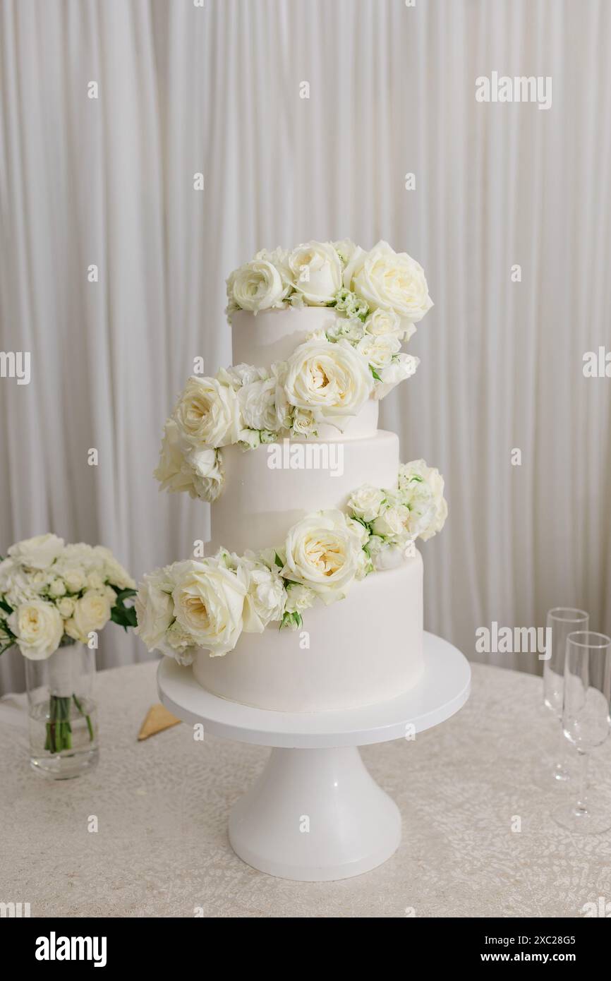 White tiered wedding cake with white roses Stock Photo