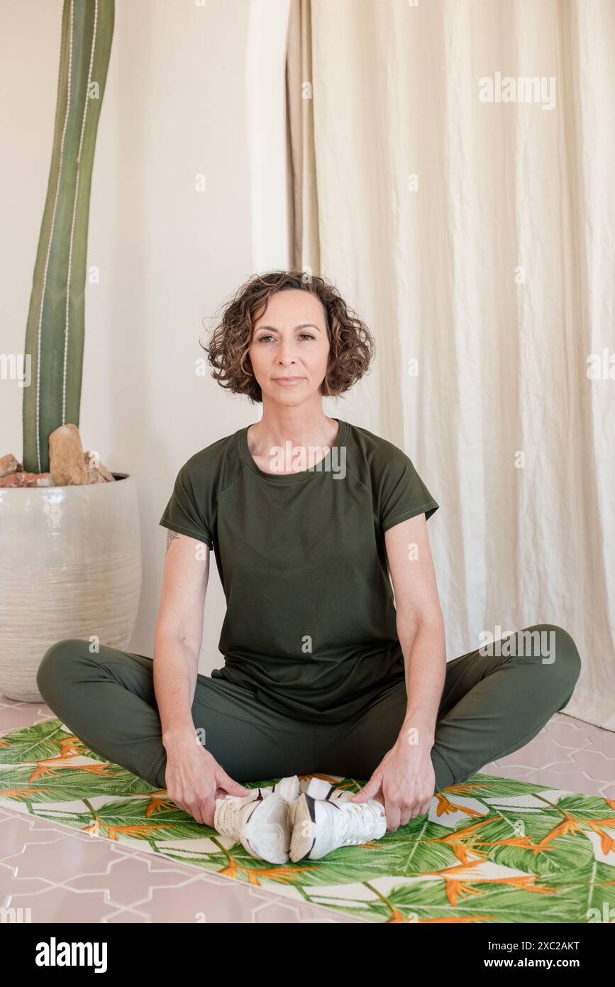 Women sitting down on yoga mat Stock Photo