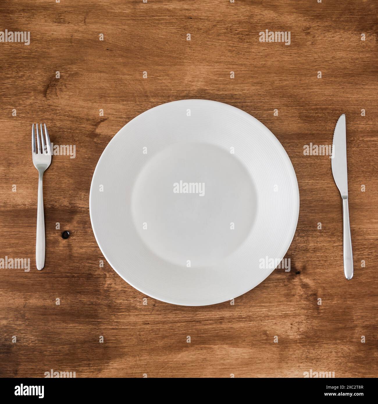empty plate with knife and fork on wooden background Stock Photo