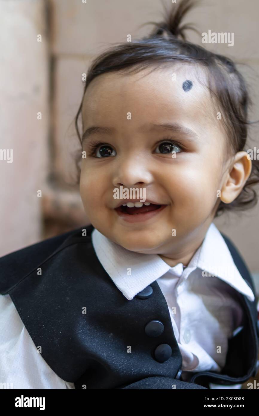 cute indian toddler baby boy in black suit at outdoor from different angle Stock Photo