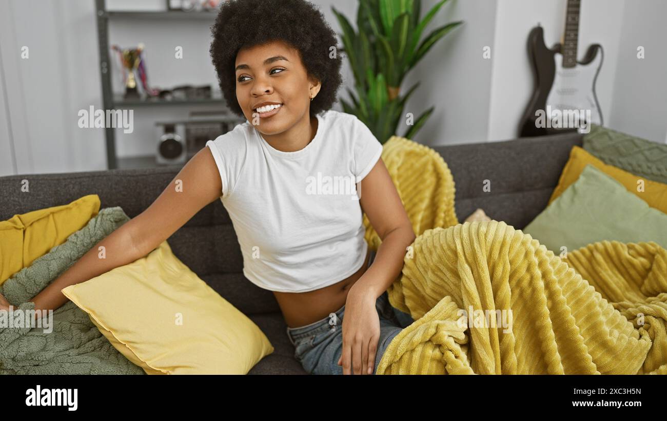 Smiling african american woman relaxing on couch in a cozy living room ...