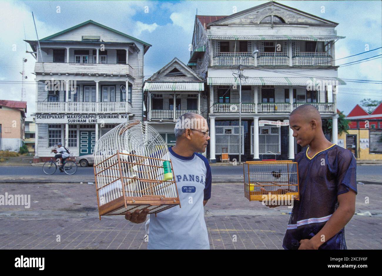 Surinam, Paramaribo. Men with songbirds in cages. Stock Photo