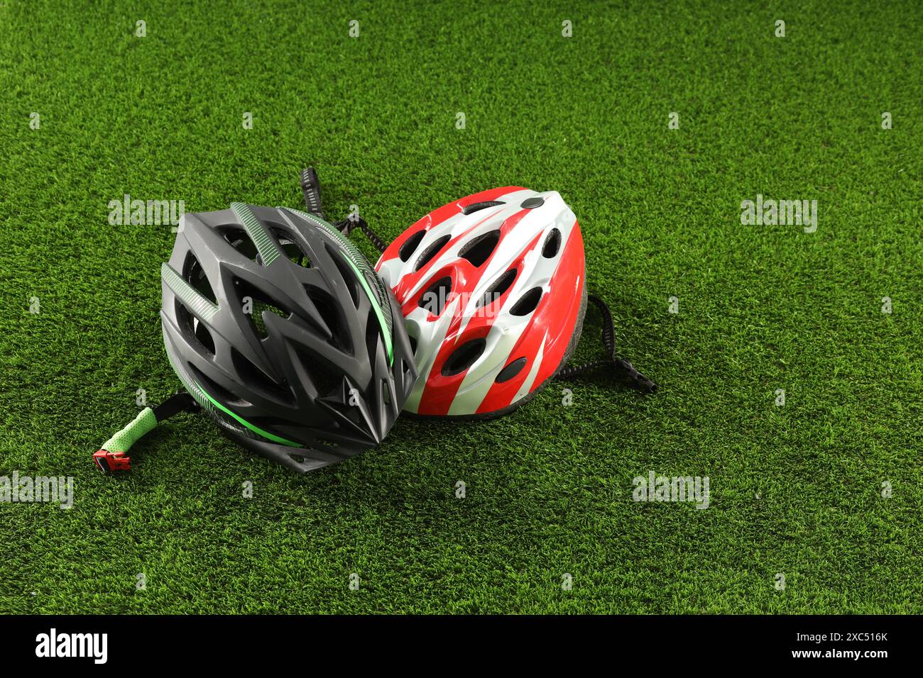 Two protective helmets on green grass. Sports equipment Stock Photo - Alamy