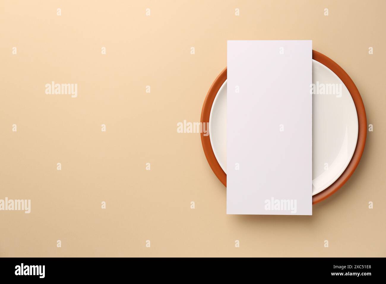 Empty menu and plates on beige background, top view. Mockup for design ...