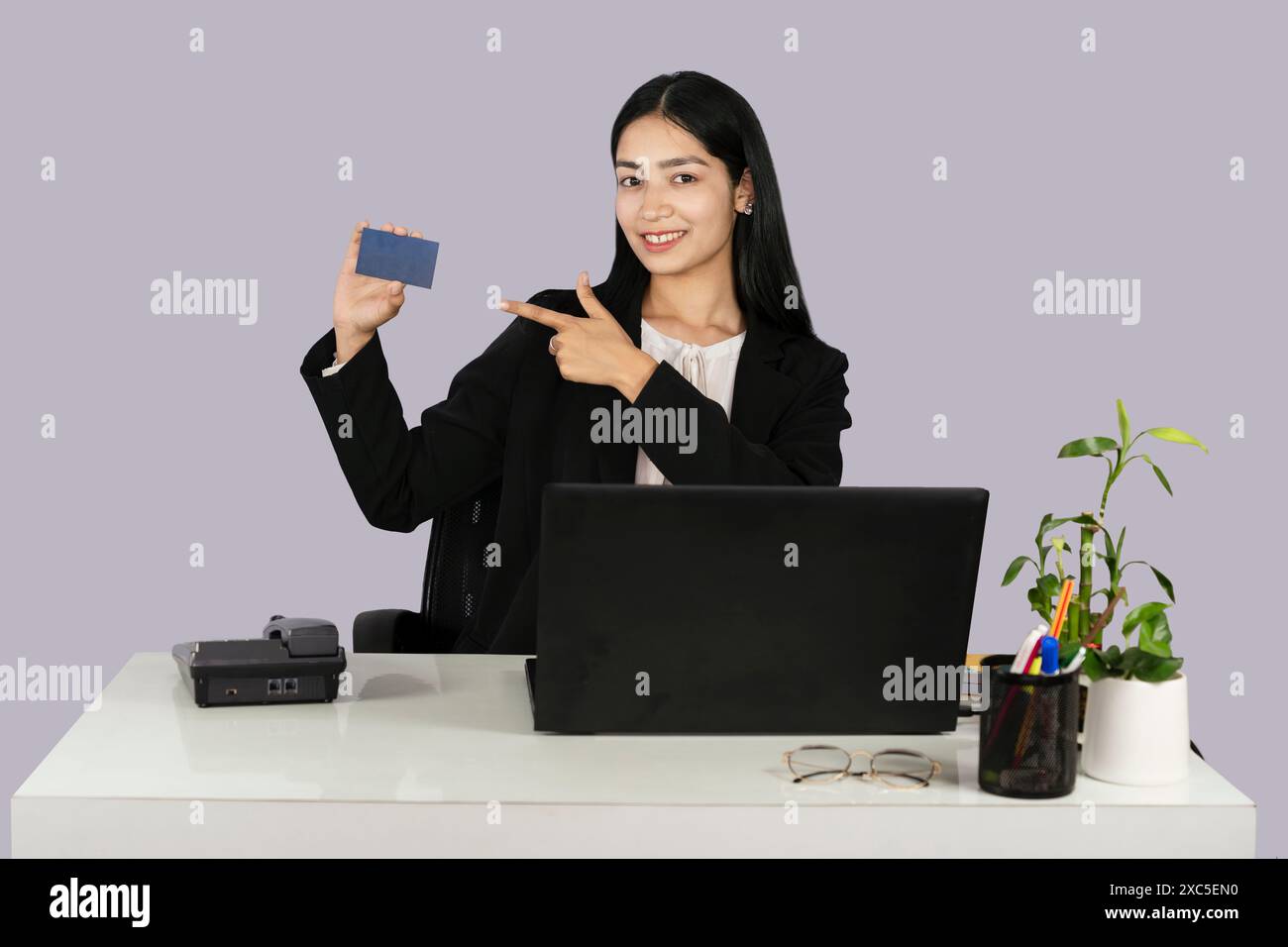 Beautiful Front Desk business woman in reception shows visiting card mockup Stock Photo