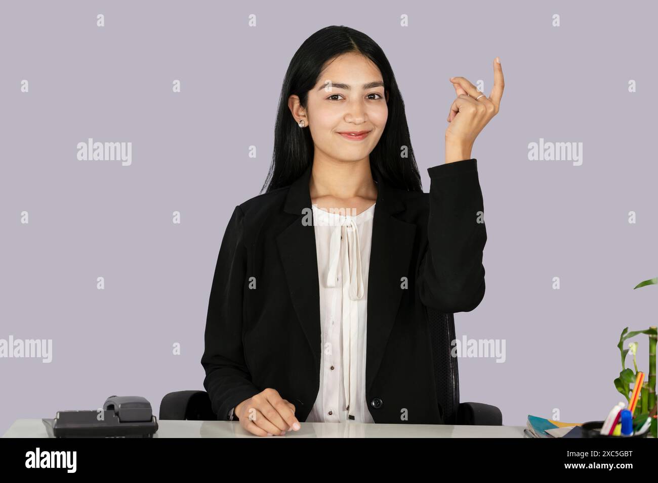 Beautiful Asian Indian Receptinist Entrepreneur with laptop, headphone and diary gives gestures  and expressions Stock Photo