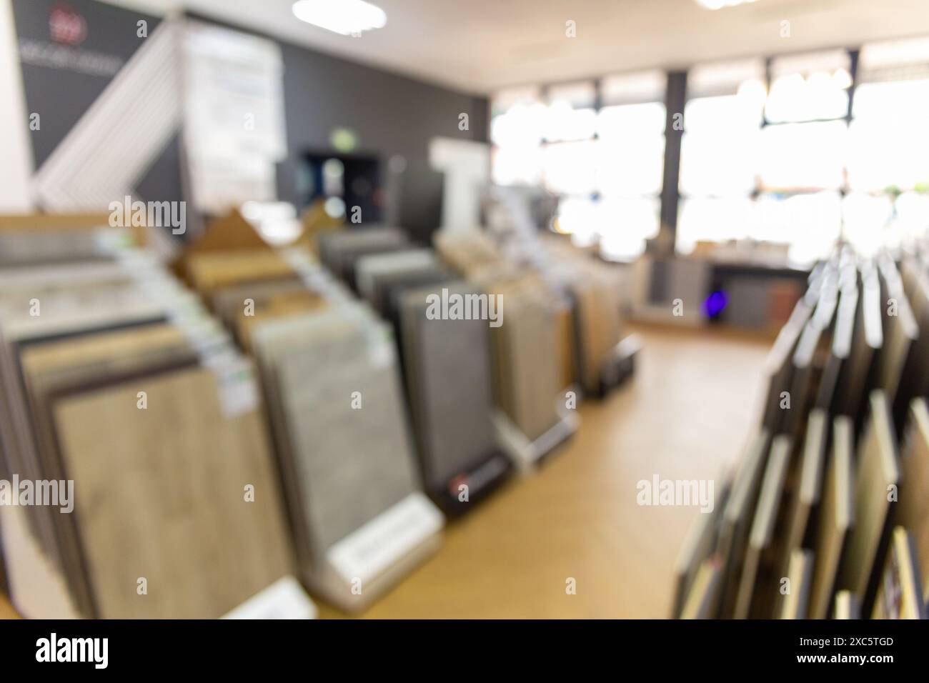 A blurred background image of the interior of a salon selling floor coverings. Assortment of laminated flooring samples in hardware store Stock Photo