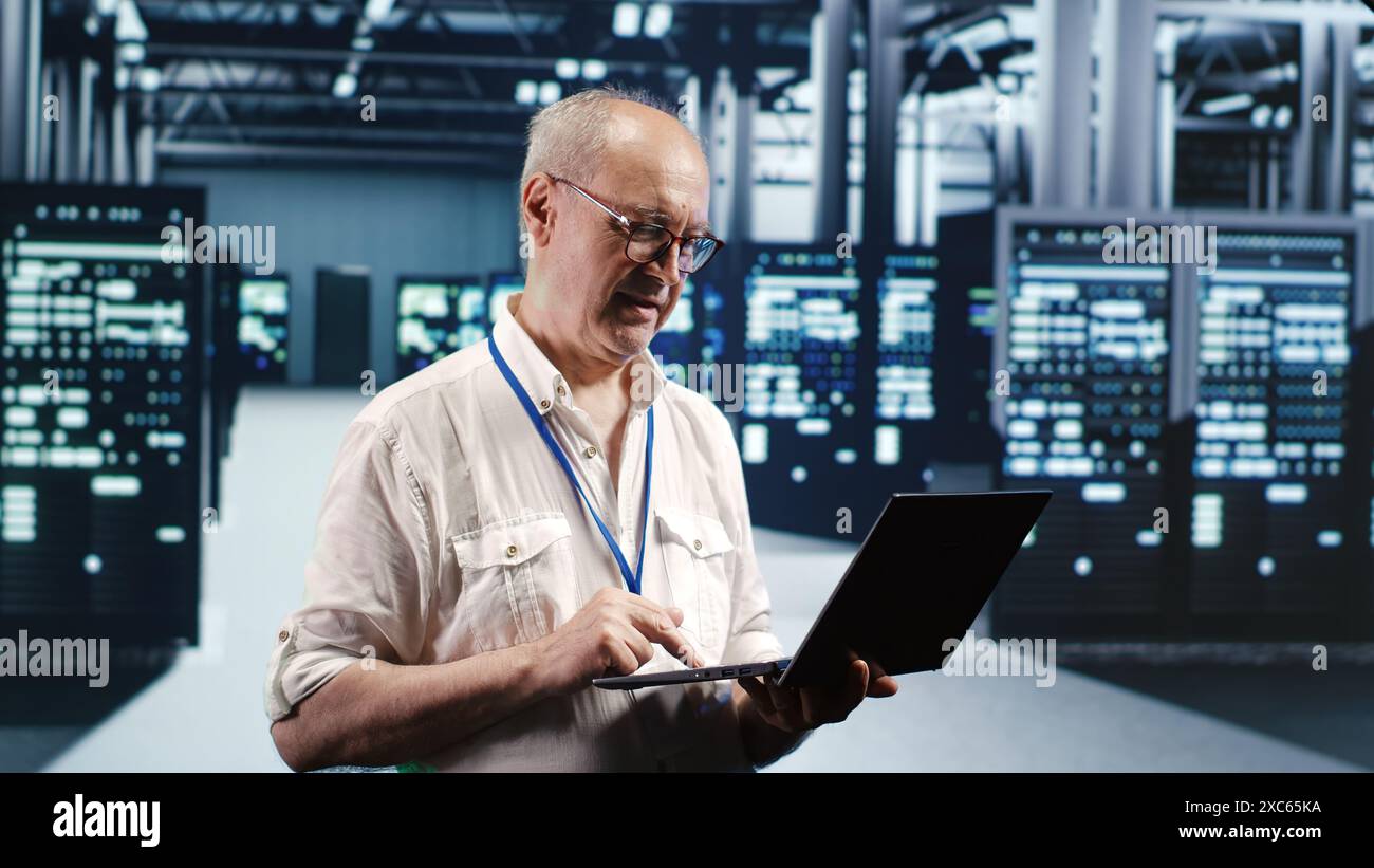 Old professional navigating network of server electronics in industrial hub. IT developer with laptop doing audit and optimizations in high tech data center, preventing system troubles Stock Photo