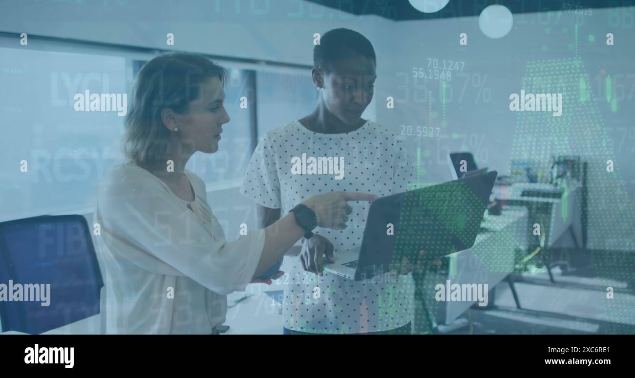 Image of financial data processing over two diverse female colleagues discussing at office Stock Photo