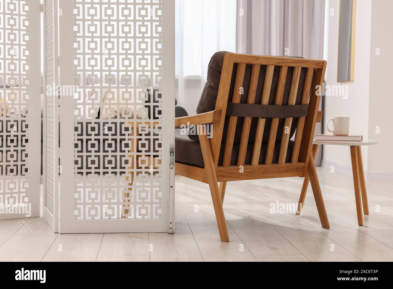 White folding screen, armchair and wooden table in living room Stock ...
