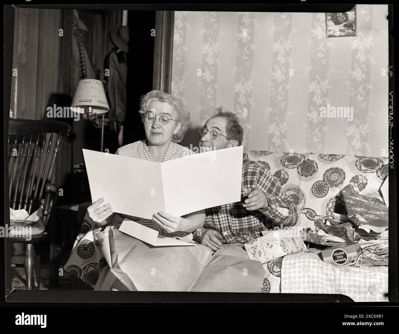 Grandma and Grandpa  with larg card. Circa 1940s. Image from 3x4 inch negative. Stock Photo