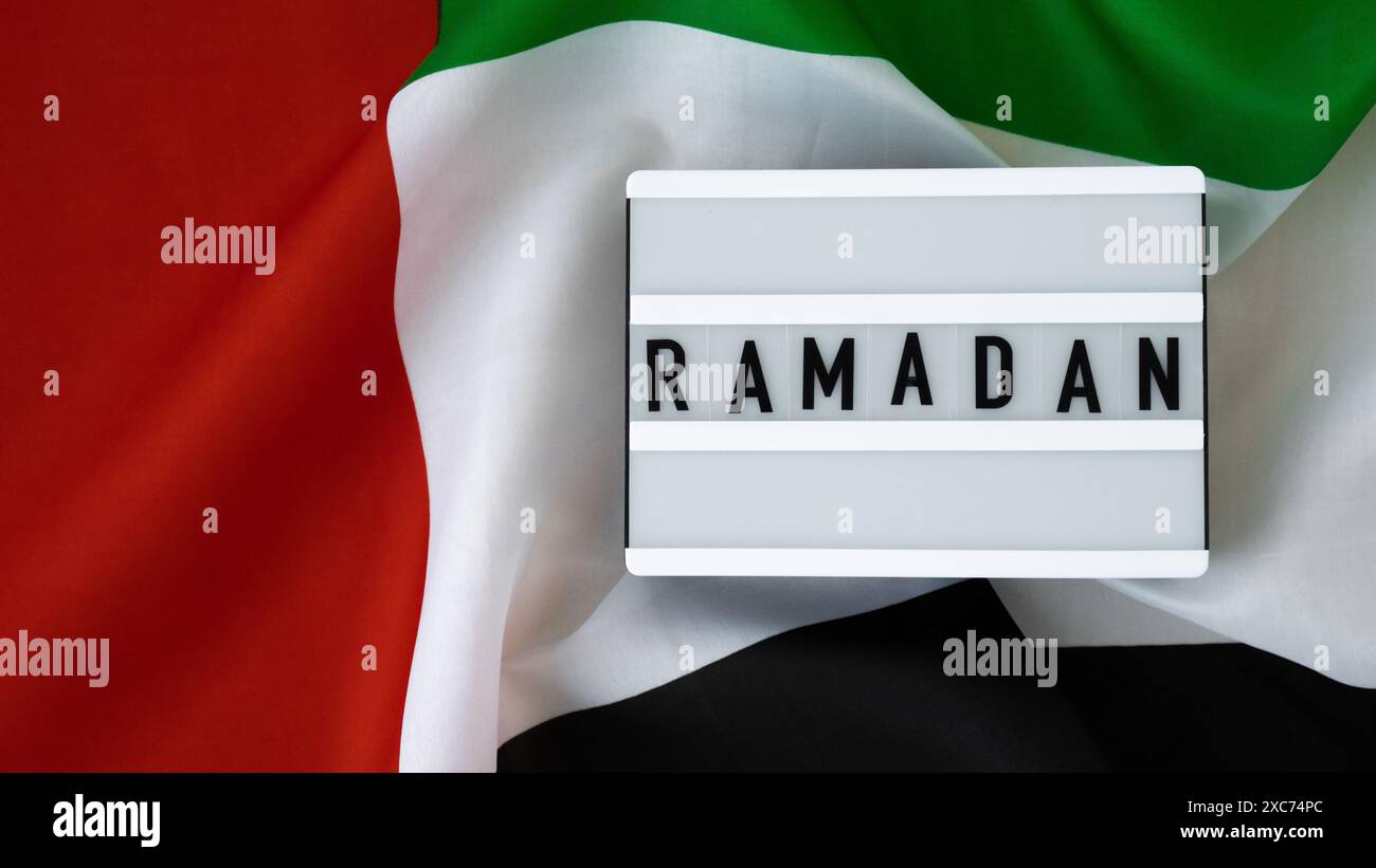 RAMADAN text frame on United Arab Emirates waving flag made from silk ...