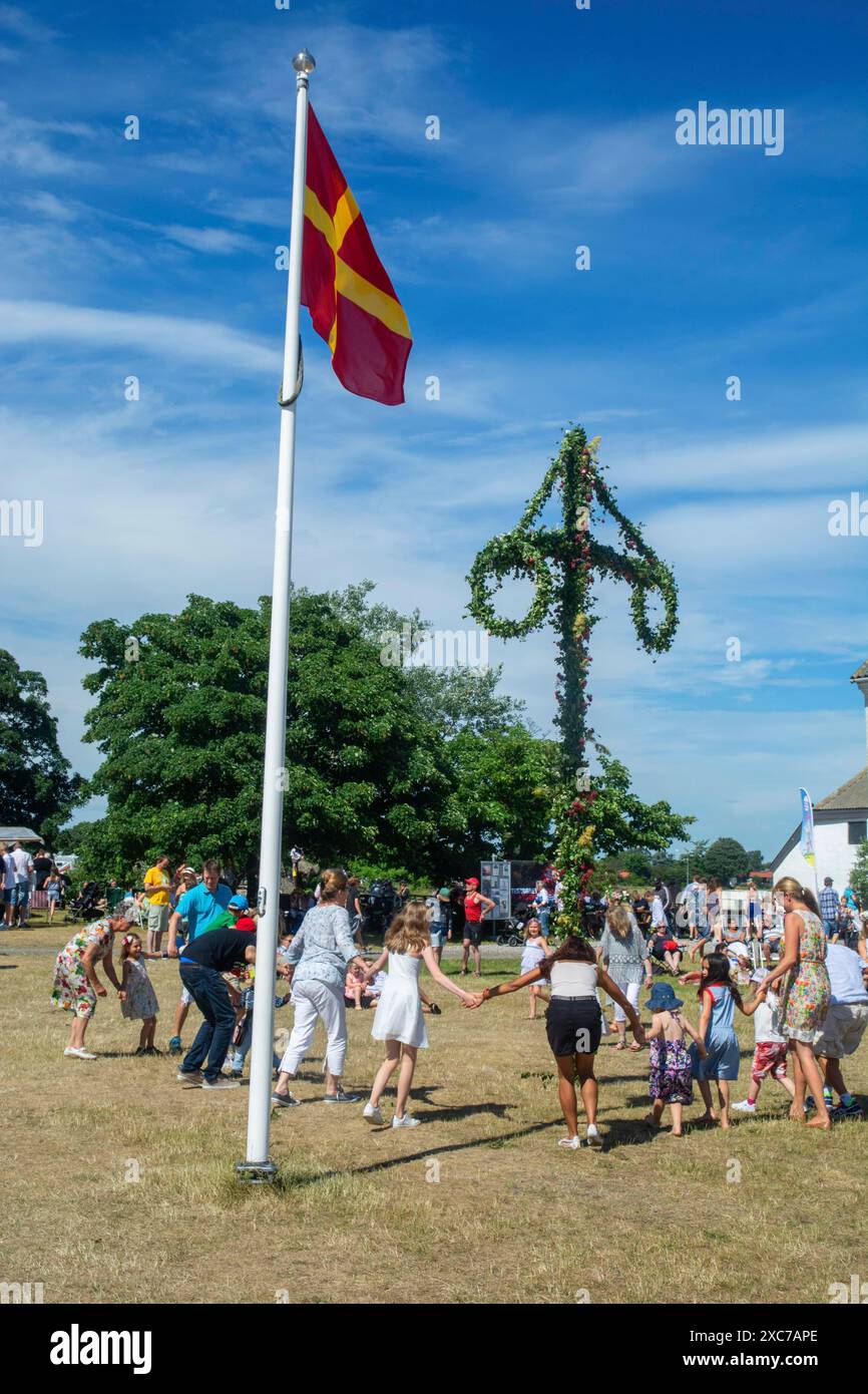 Traditional midsummer celebration with dancing around the maypole at ...