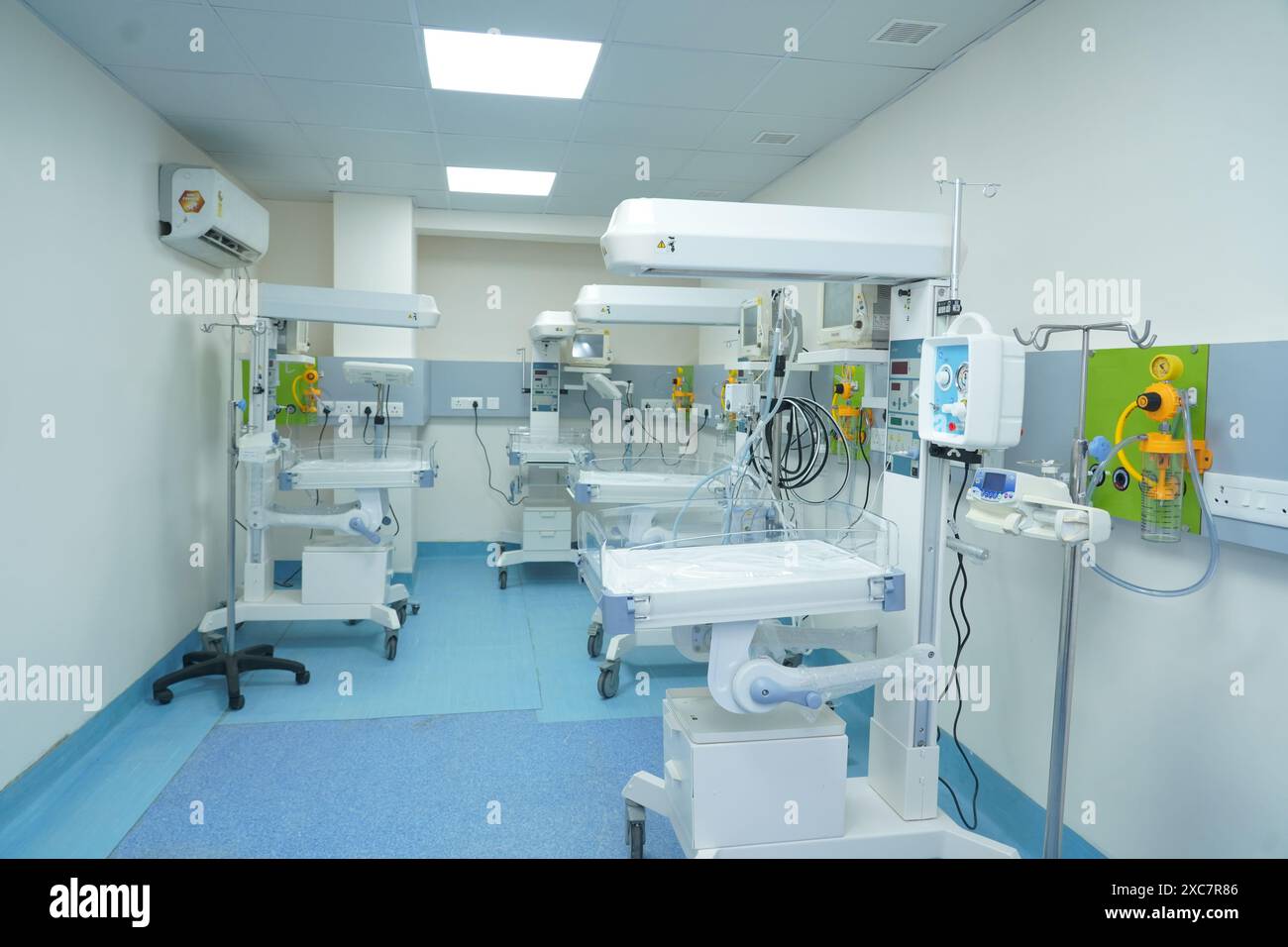 NICU equipment includes incubators, ventilators, monitors, IV pumps, and phototherapy lights. Stock Photo