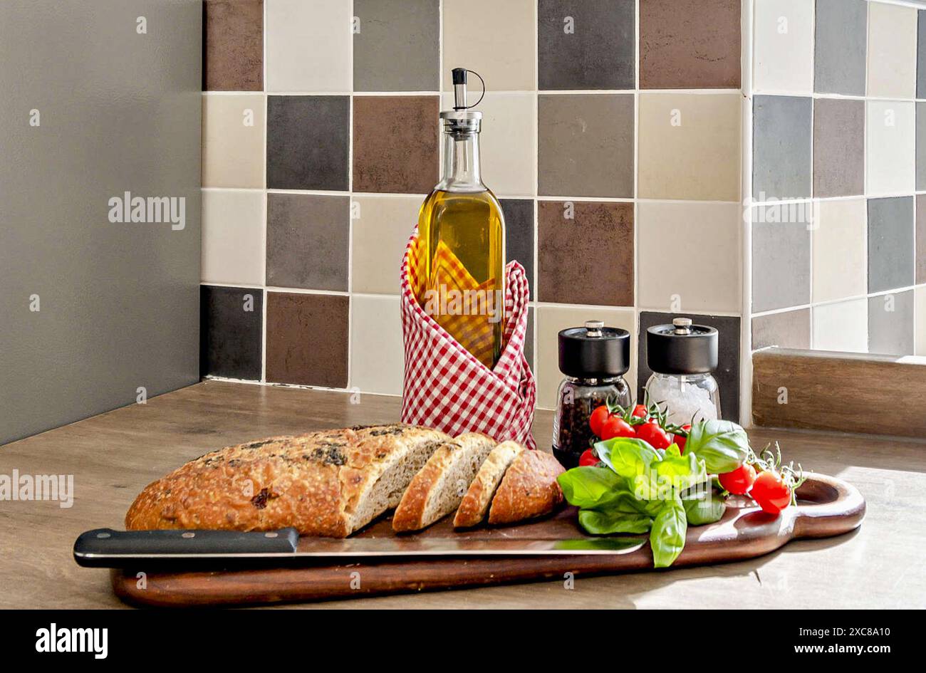 Tomatoes  basil  and  fresh  bread  on a  woden  chopping  board Stock Photo