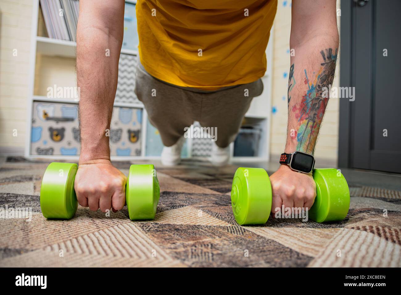 Man Doing Push Ups With Dumbbells At Home Stock Photo