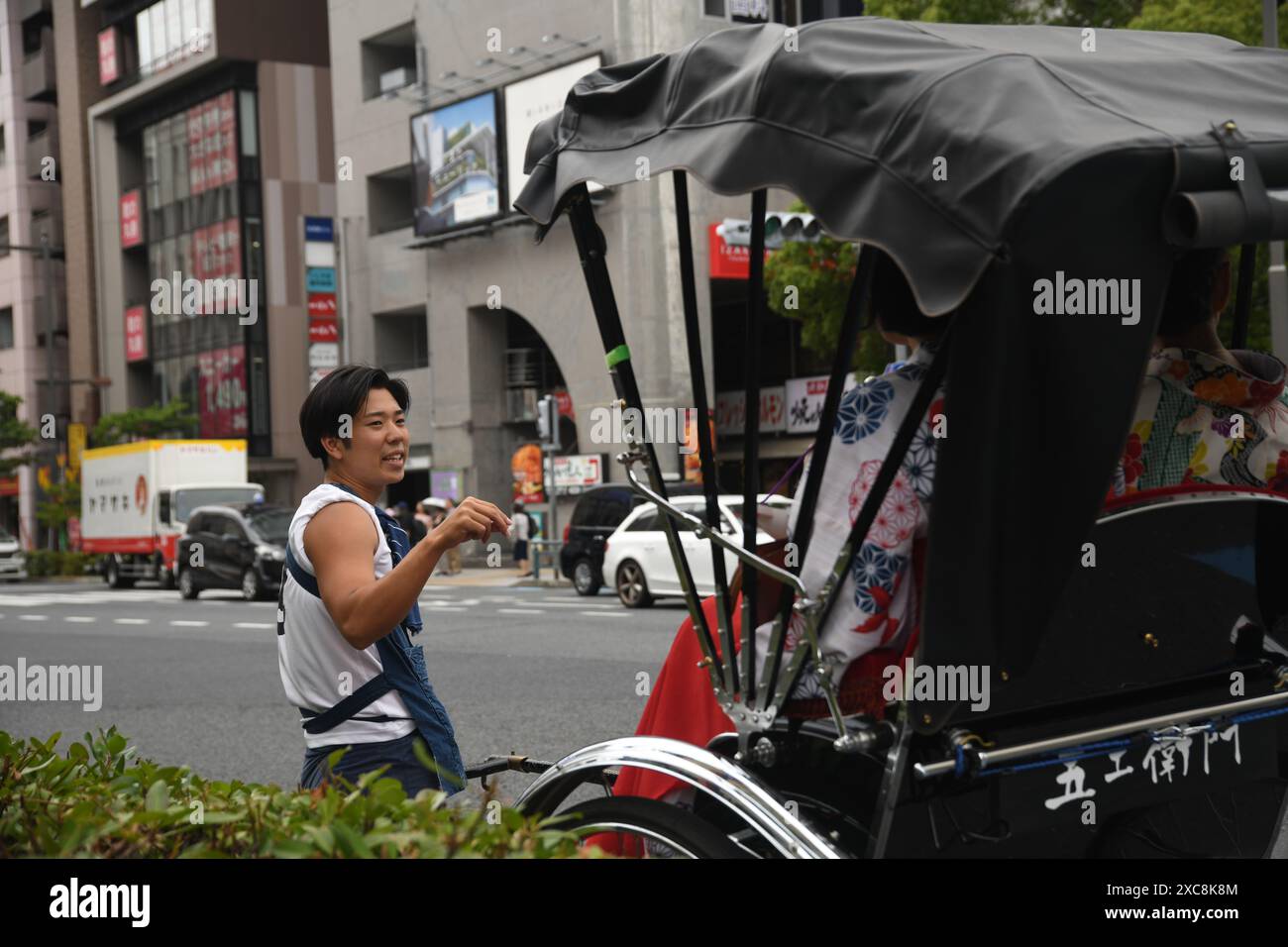 Japanese man carrying a typical japanese rickshaw with tourists on the ...