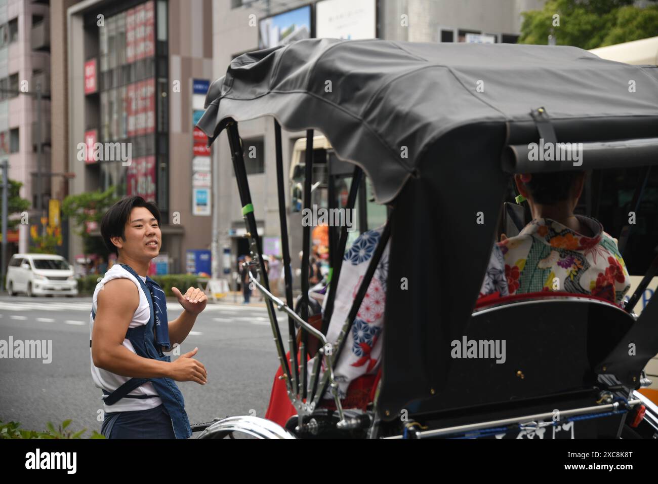 Japanese man carrying a typical japanese rickshaw with tourists on the ...