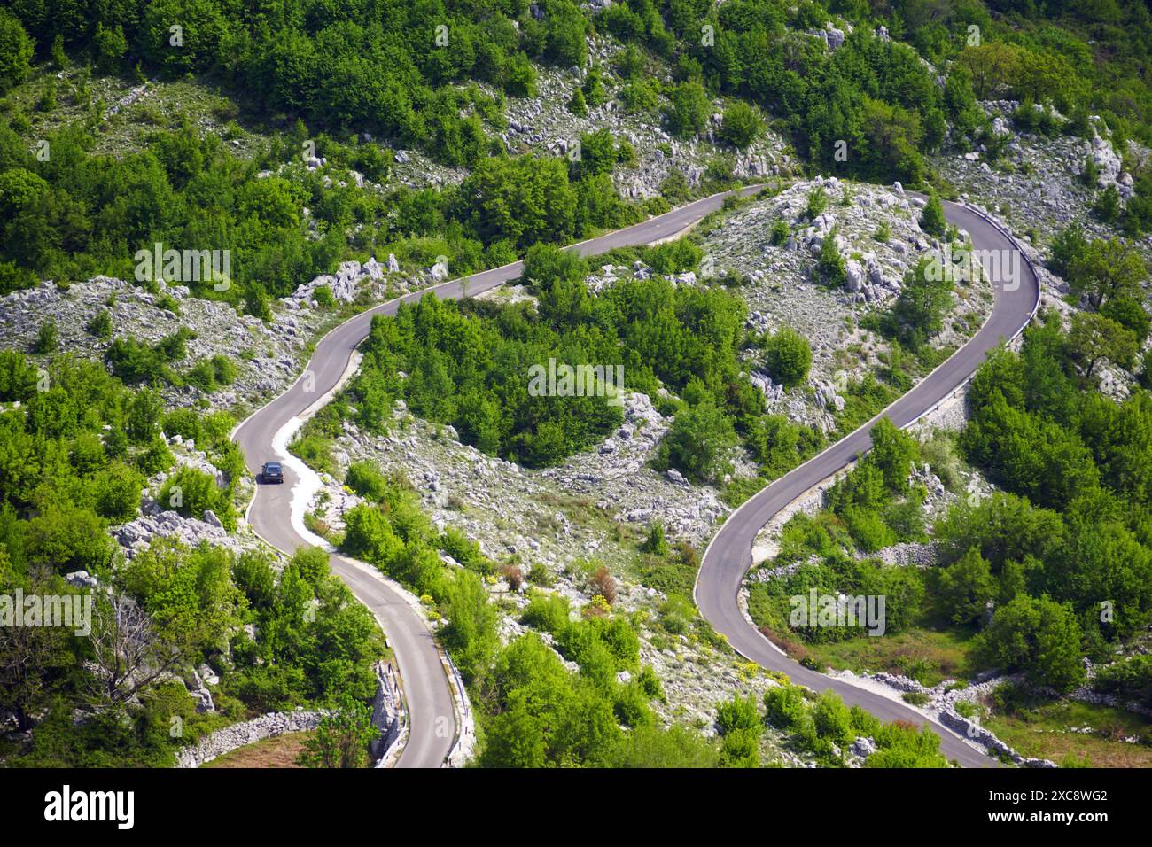 Top view of a winding road along which a car is moving. Mountain serpentine leading to the village of Vrbanj (municipality of Herceg Novi, Montenegro) Stock Photo