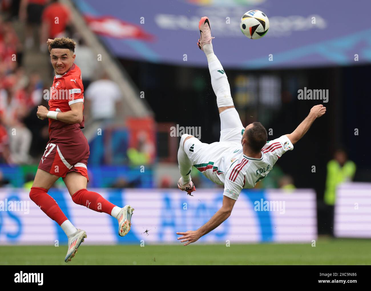 Cologne, Germany. 15th June, 2024. Ruben Vargas of Switzerland looks over his shoulder as Attila Fiola of Hungary clears the ball with an overhead kick during the UEFA European Championships match at Cologne Stadium, Cologne. Picture credit should read: Jonathan Moscrop/Sportimage Credit: Sportimage Ltd/Alamy Live News Stock Photo