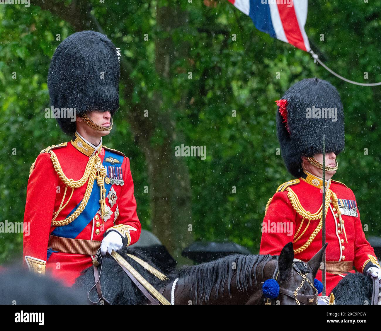 London, UK 15th Jun 2024.  Prince William, Prince of Wales returns to Buckingham Palace on horseback through heavy rain, following the Trooping the Colour ceremony. Trooping the Colour takes place each year to celebrate the monarch's official birthday. This year it was the turn of the Irish Guards to troop their colour. The procession, to and from Horse Guards Parade passes along the Mall. Credit: MartinJPalmer/Alamy Live News Stock Photo