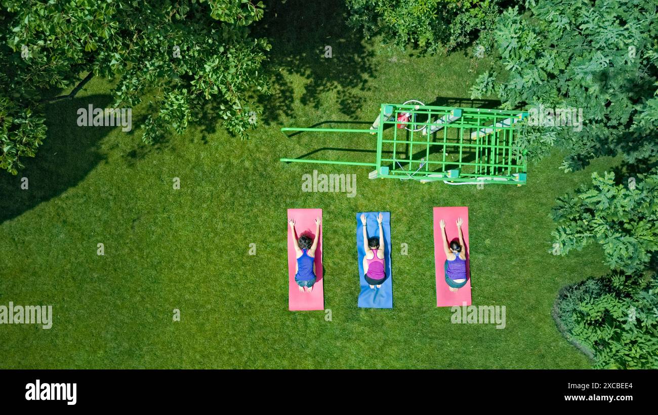 Family fitness and sport outdoors, group of active girls doing workout in park, women exercising outdoor aerial top view from above Stock Photo