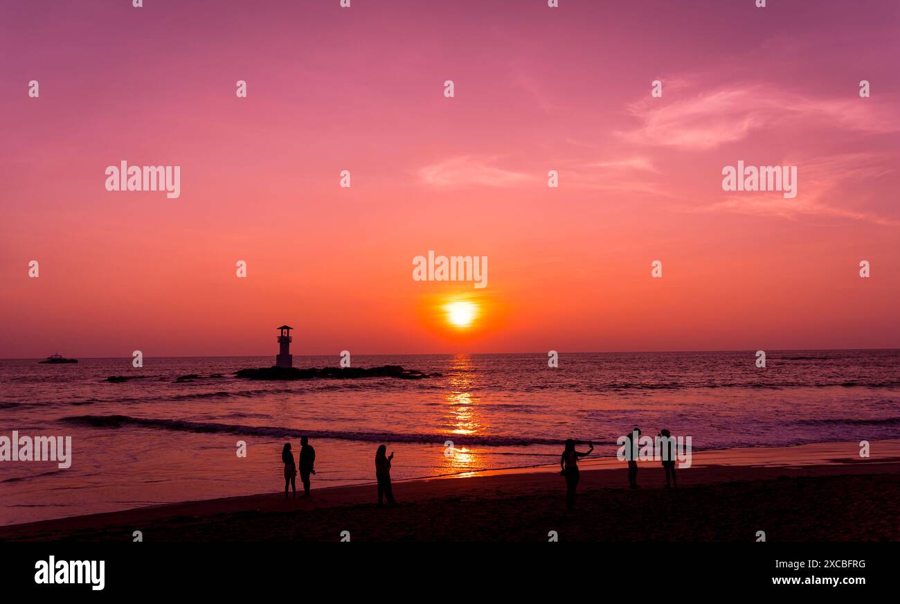 A lighthouse in the ocean during a beautiful sunset Stock Photo - Alamy