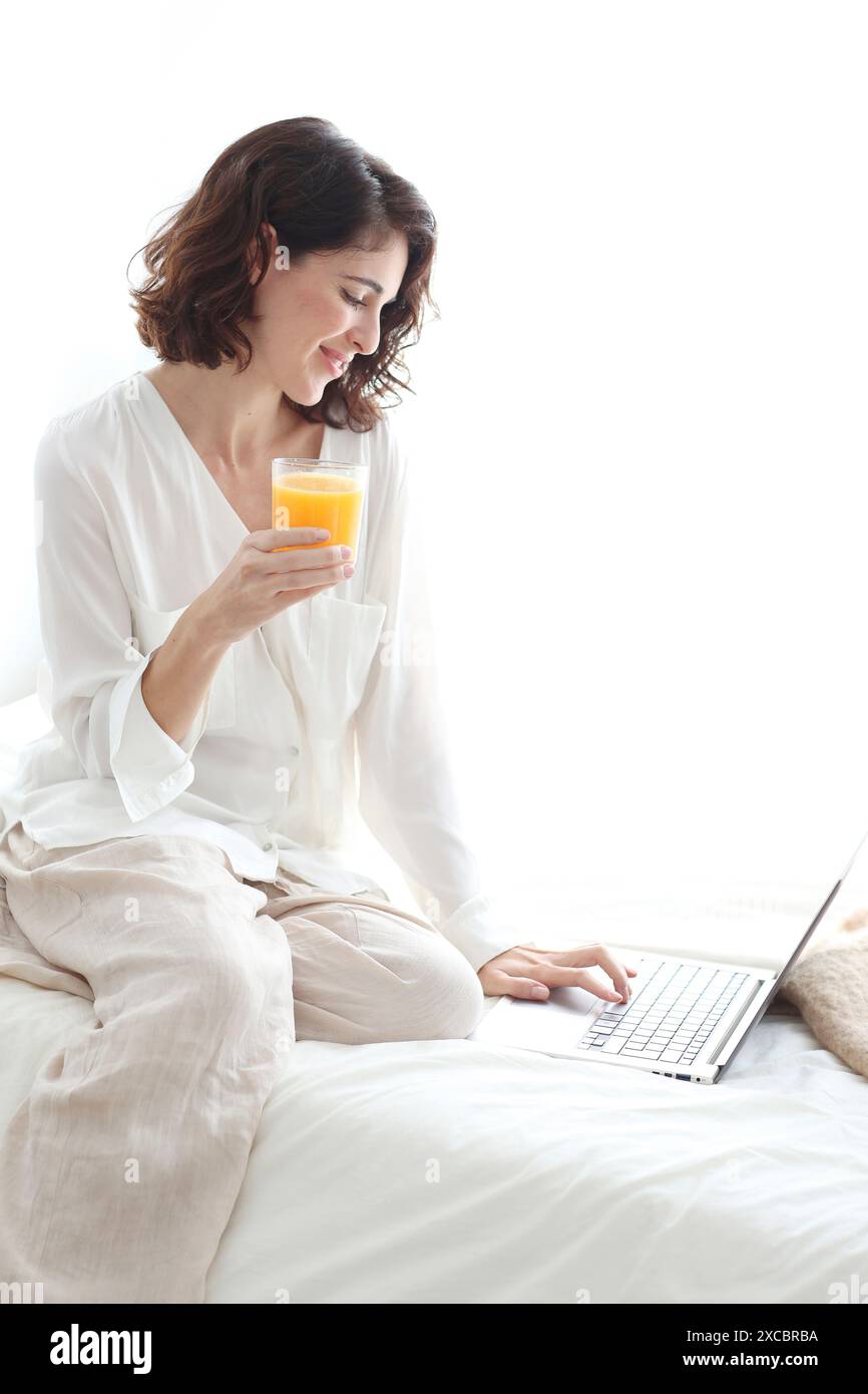 Woman using laptop computer and smiling Stock Photo