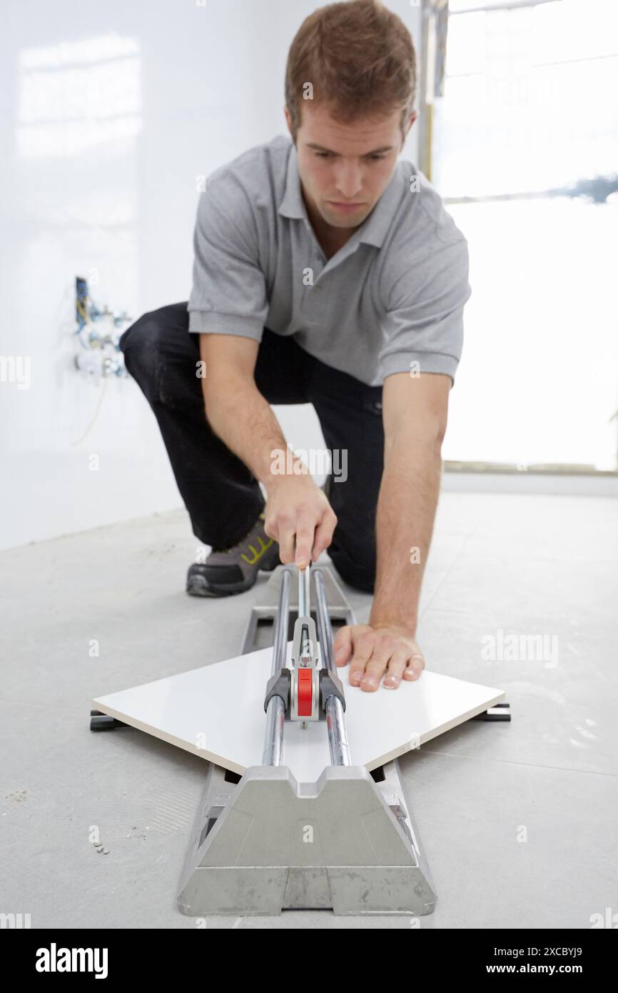 Bricklayer cutting tile. Manual tile cutter. Construction Industry. Stock Photo