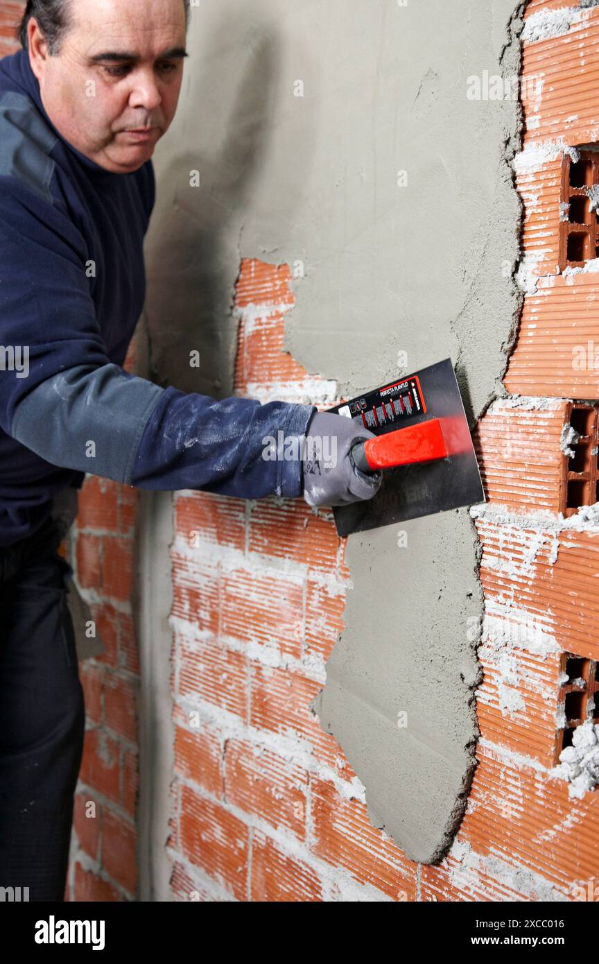 Rendering a brick wall using trowel, new homes under construction, construction site Stock Photo