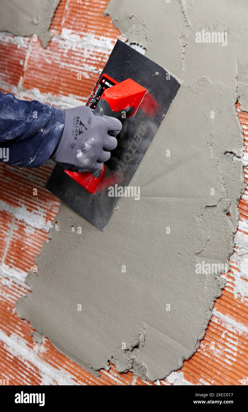 Rendering a brick wall using trowel, new homes under construction, construction site Stock Photo