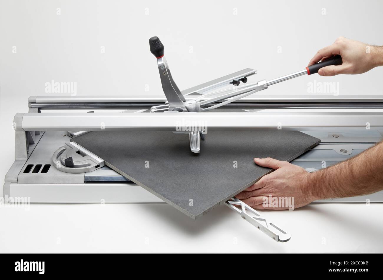 Bricklayer cutting tile. Manual tile cutter. Construction Industry. Stock Photo