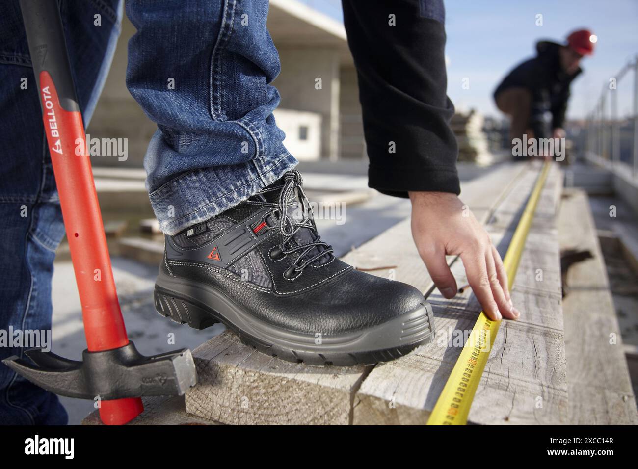 Construction workers measuring, personal protective equipment, housing construction Stock Photo
