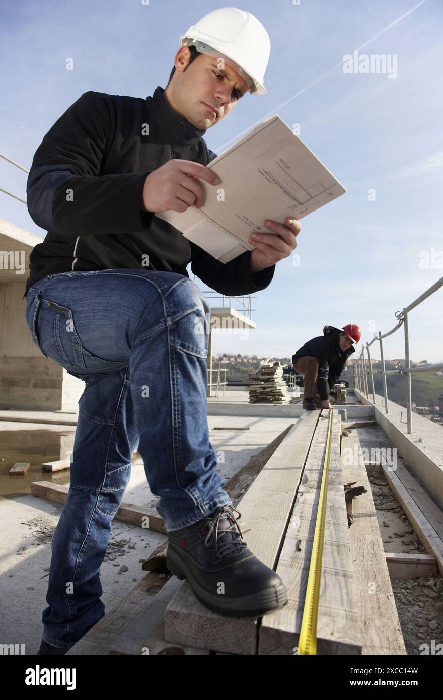 Construction workers measuring, personal protective equipment, housing construction Stock Photo