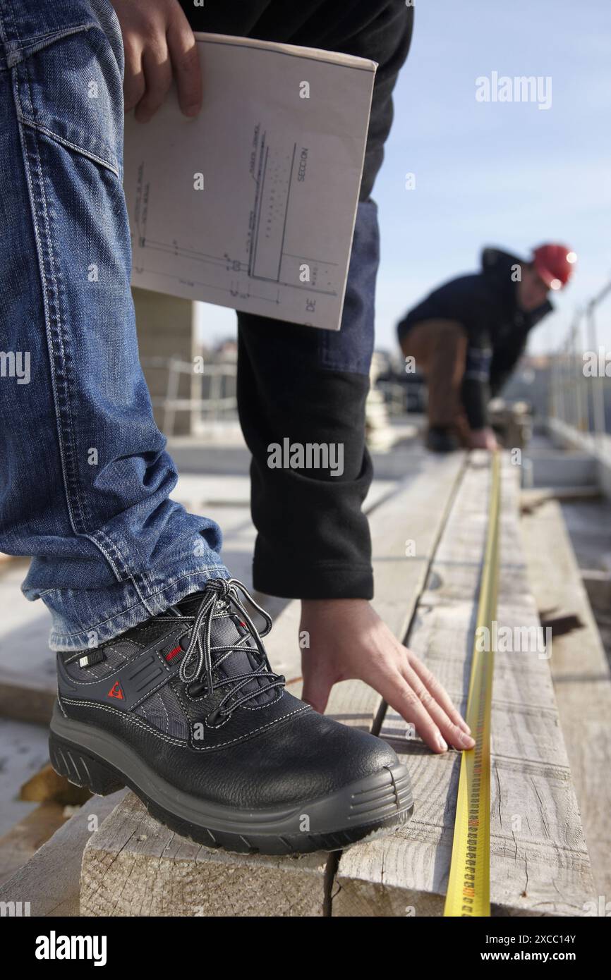 Construction workers measuring, personal protective equipment, housing construction Stock Photo
