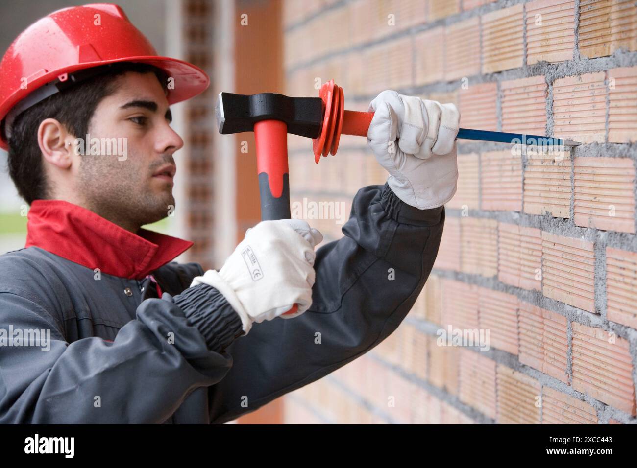 Worker with mallet and chisel, building construction. Stock Photo