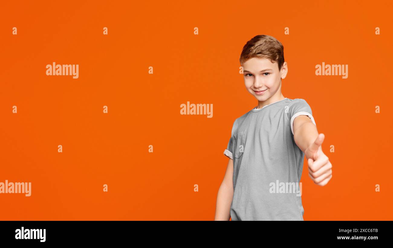 Cute teen boy showing thumb up gesture Stock Photo - Alamy