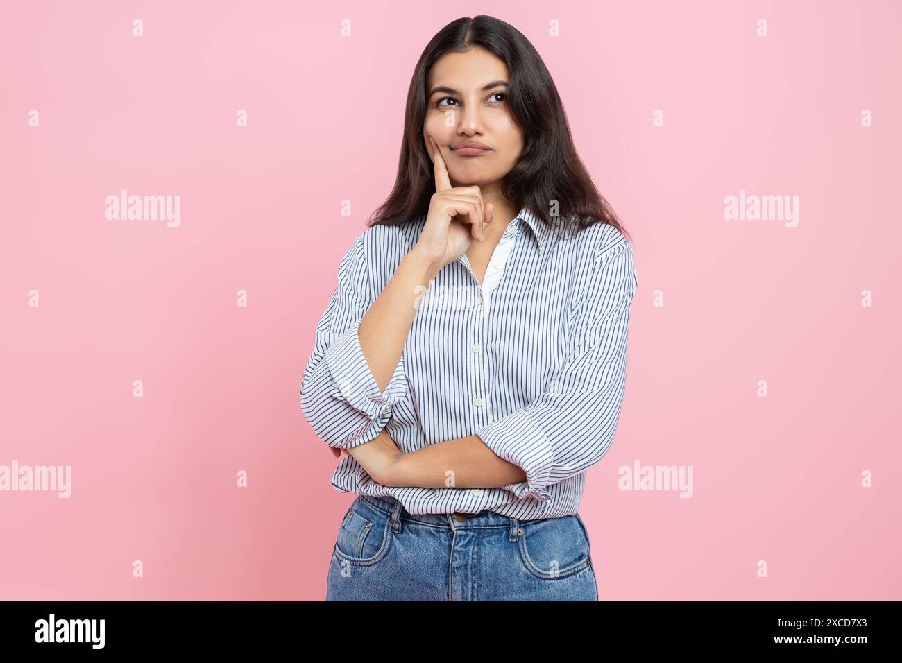Pensive Indian woman holding chin thinking Stock Photo - Alamy