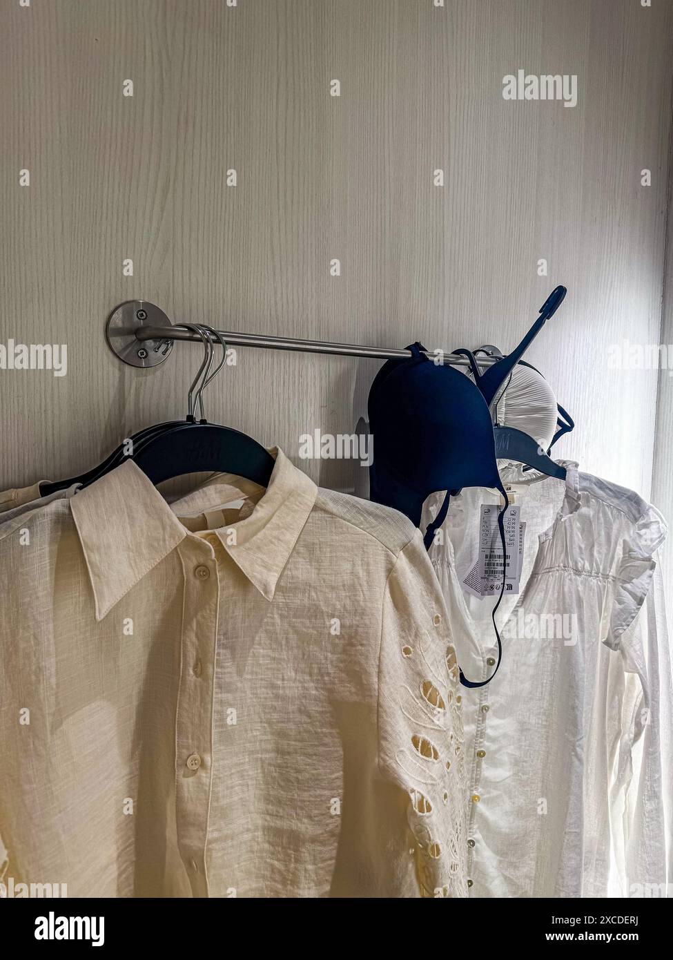 A row of clothes hanging on the rack in fitting room in department ...