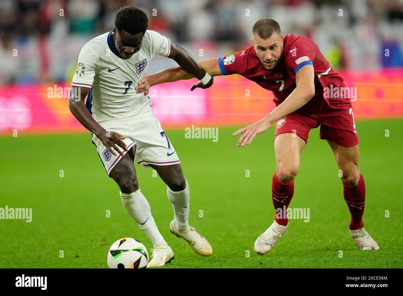 England's Bukayo Saka, left, challenges for the ball with Serbia's