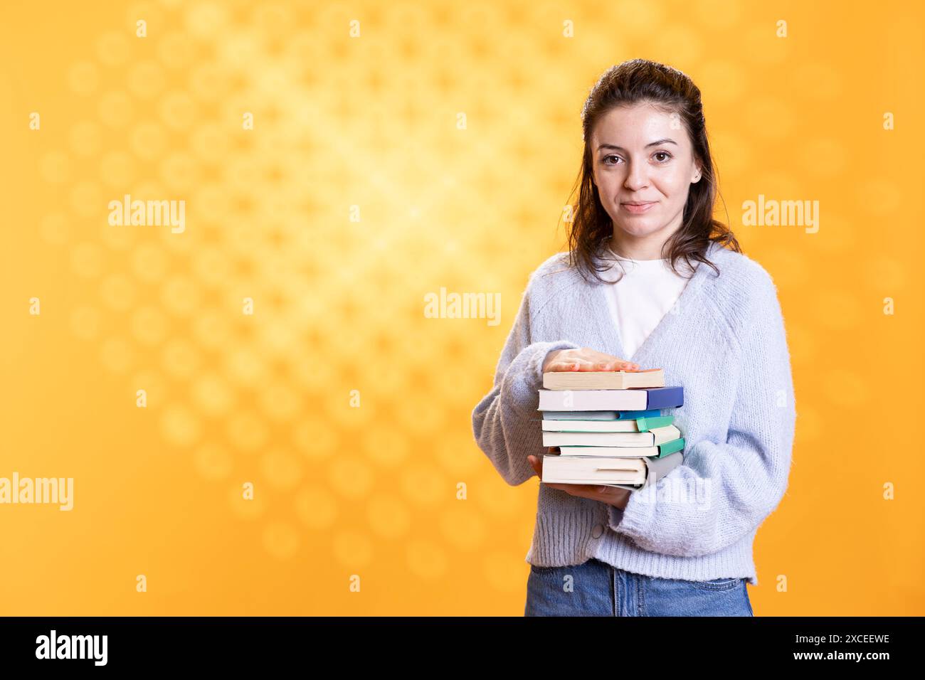 Using Books Portrait of woman holding stack of books needed for her education ...