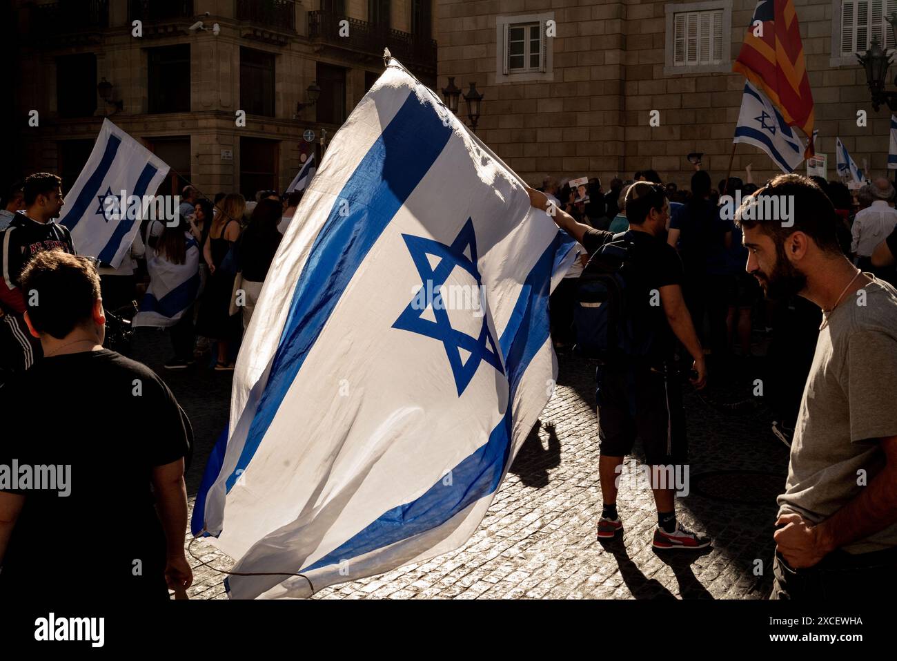 In Barcelona, ​​a man holds an Israeli flag during a protest against anti-Semitism and for the freedom of Israeli hostages kidnapped by Hamas. Stock Photo
