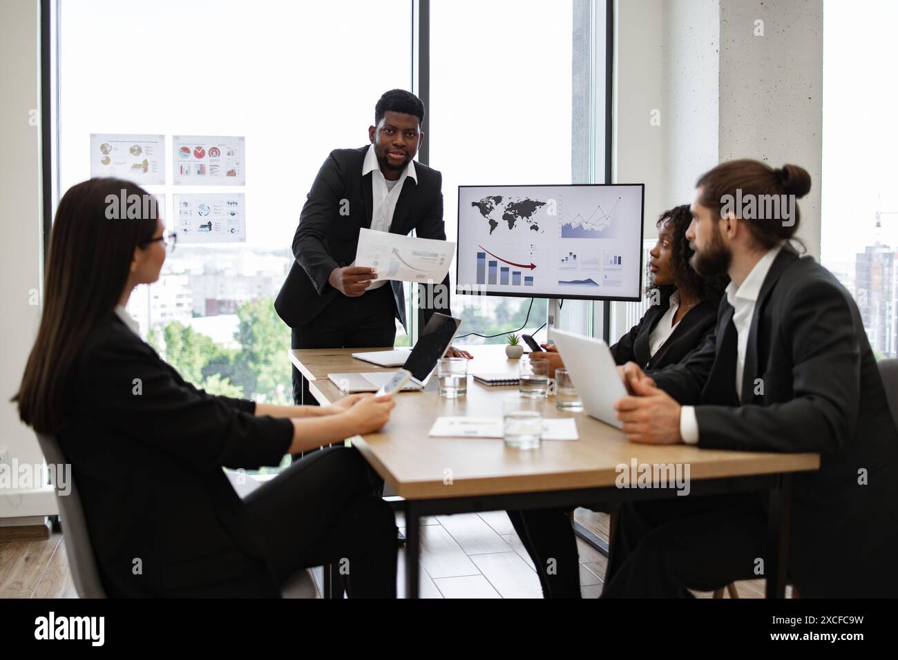 Business meeting presentation in modern office with charts and graphs ...