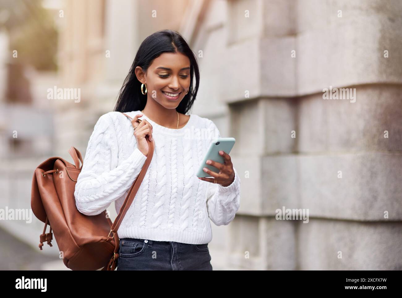 Outdoor, smile and Indian woman in campus, phone and notification of results, exam and application to college. University, student and mobile for Stock Photo